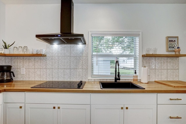 kitchen featuring wall chimney exhaust hood, sink, white cabinets, and tasteful backsplash