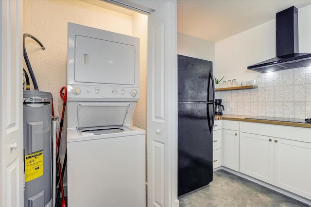 laundry room with stacked washer / dryer and electric water heater