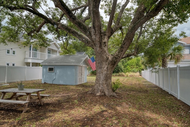 view of yard featuring a storage shed and a balcony