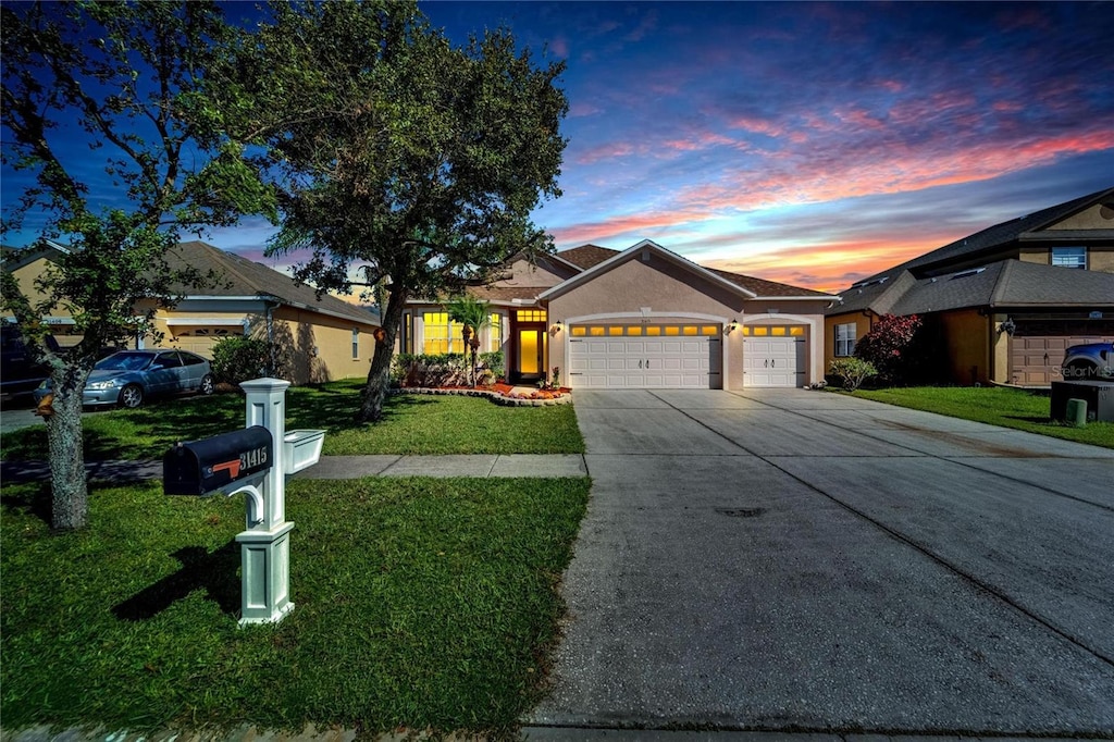 ranch-style home with a yard and a garage