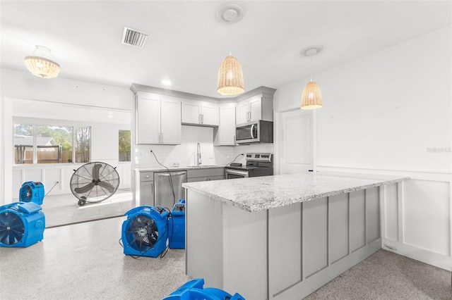 kitchen featuring sink, hanging light fixtures, gray cabinetry, stainless steel appliances, and light stone countertops