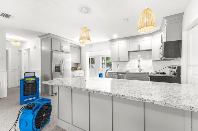 kitchen featuring appliances with stainless steel finishes, hanging light fixtures, gray cabinetry, and sink