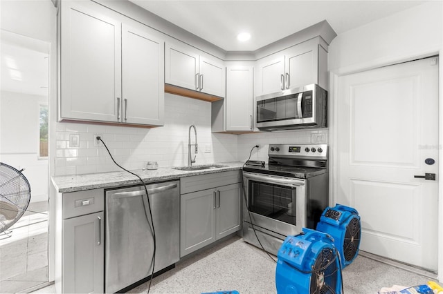 kitchen with decorative backsplash, appliances with stainless steel finishes, gray cabinets, and sink