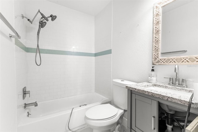 full bathroom with tiled shower / bath, vanity, and toilet