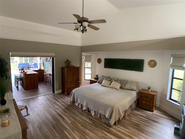 bedroom with lofted ceiling, multiple windows, ceiling fan, and hardwood / wood-style floors