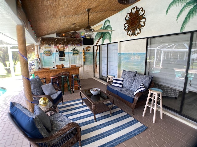 sunroom / solarium featuring bar, ceiling fan, and vaulted ceiling