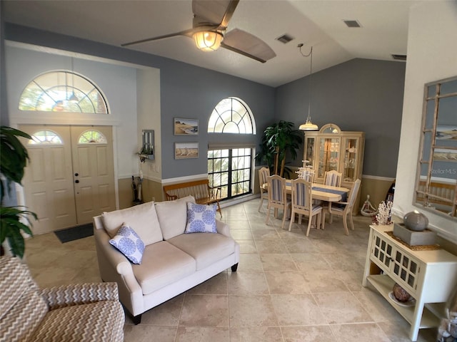 living room featuring lofted ceiling, ceiling fan, and light tile patterned floors