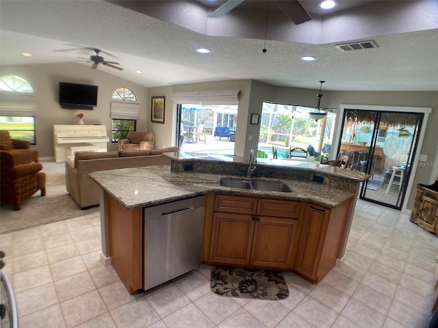 kitchen featuring sink, light stone countertops, dishwasher, and an island with sink