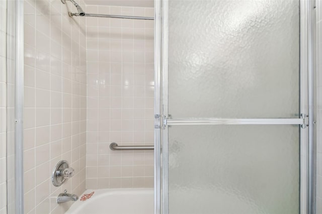 bathroom featuring bath / shower combo with glass door