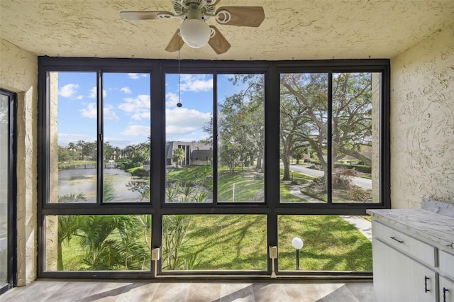 unfurnished sunroom with a healthy amount of sunlight and ceiling fan