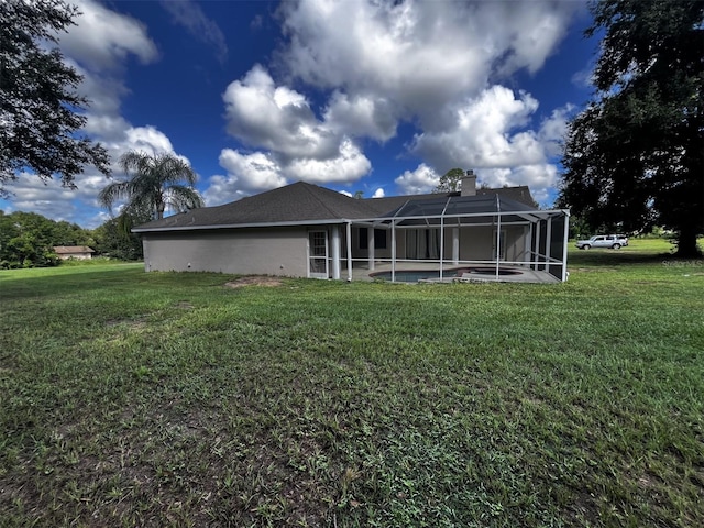 back of property with a lawn and a lanai