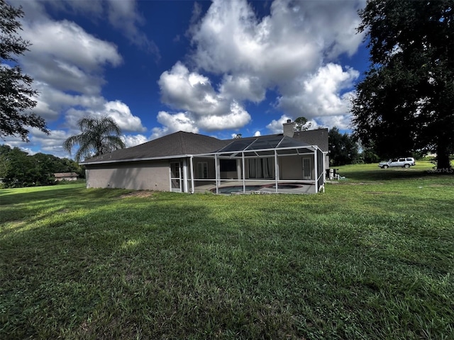 back of property featuring a lanai, a patio, and a lawn