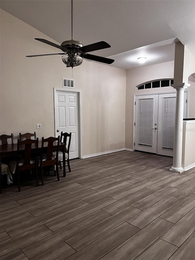 dining room with ceiling fan, a textured ceiling, dark wood-type flooring, and decorative columns