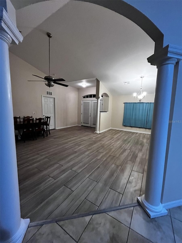 unfurnished living room with ceiling fan with notable chandelier, wood-type flooring, and decorative columns