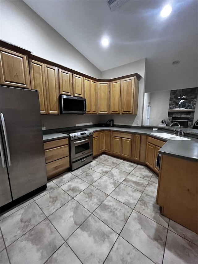 kitchen with lofted ceiling, appliances with stainless steel finishes, and sink