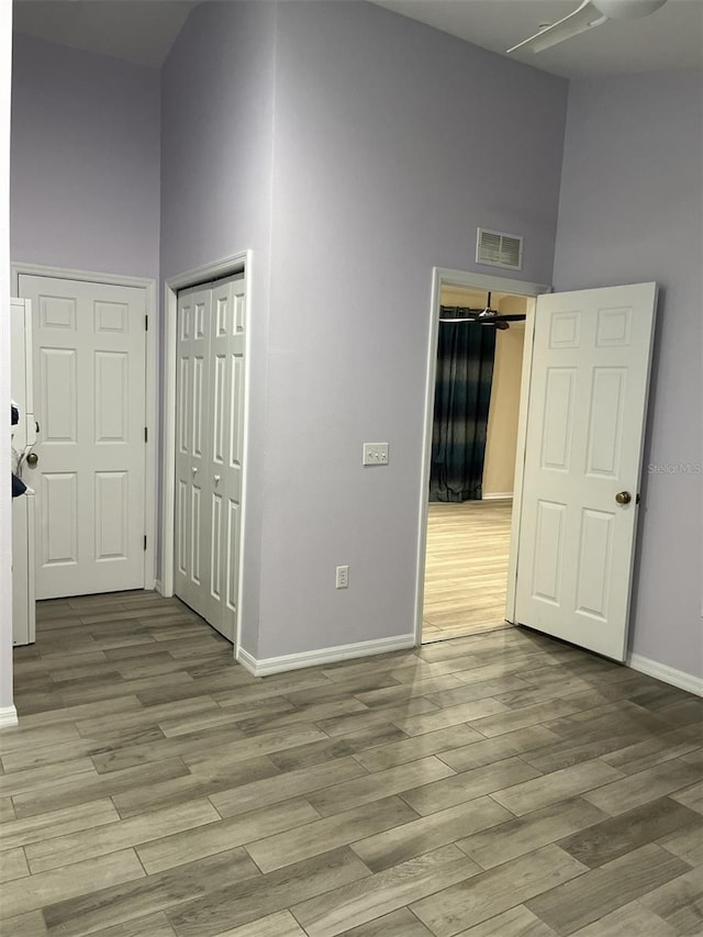 empty room with a high ceiling and light hardwood / wood-style flooring