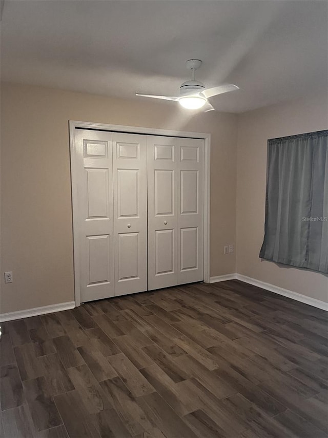 unfurnished bedroom with dark hardwood / wood-style floors, ceiling fan, and a closet