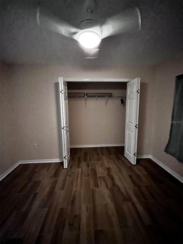 unfurnished bedroom with a textured ceiling and dark hardwood / wood-style flooring