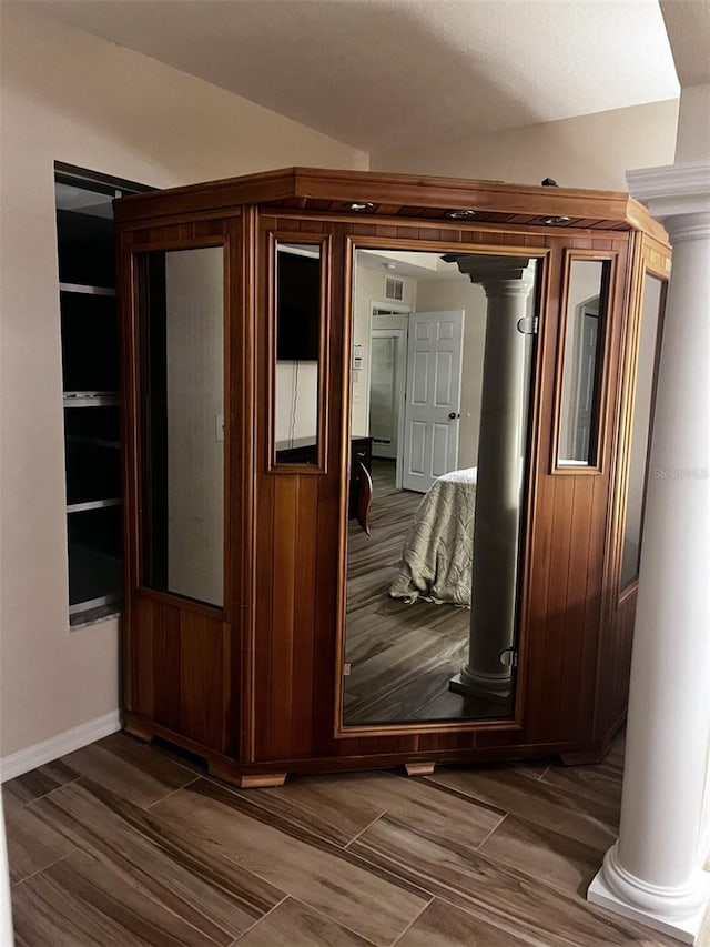 corridor with vaulted ceiling and dark hardwood / wood-style floors