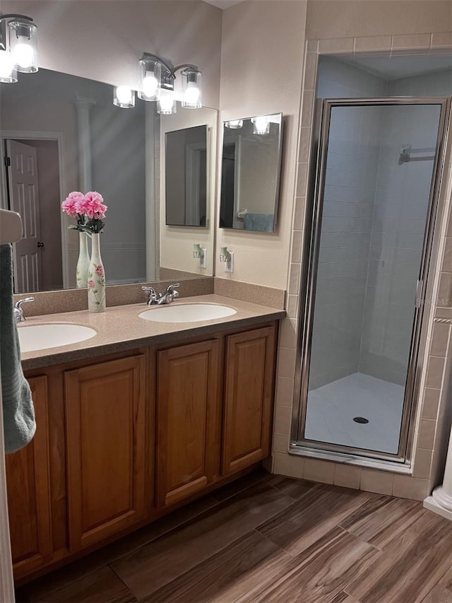 bathroom with walk in shower, vanity, decorative columns, and hardwood / wood-style floors