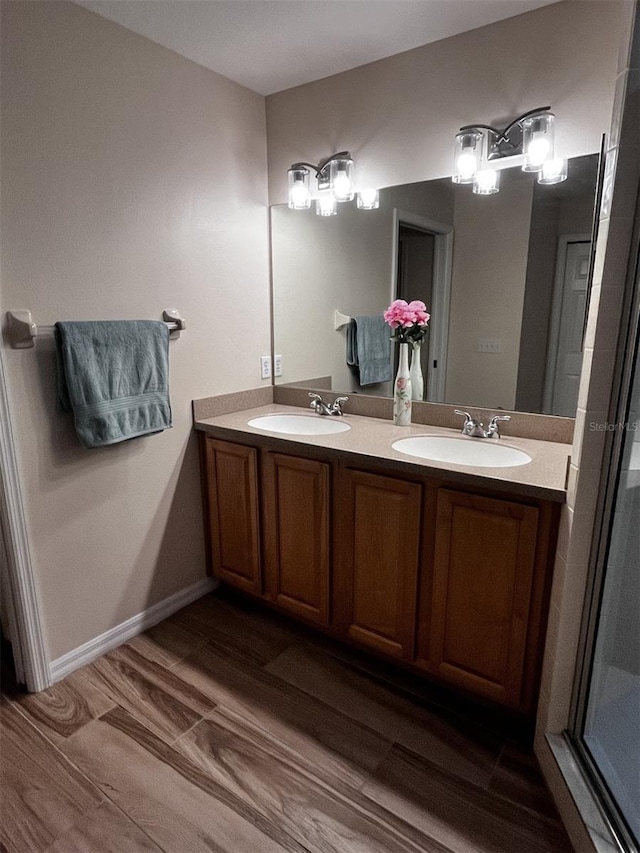 bathroom featuring wood-type flooring, vanity, and a shower with door