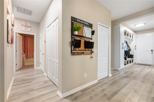 hallway with light hardwood / wood-style floors