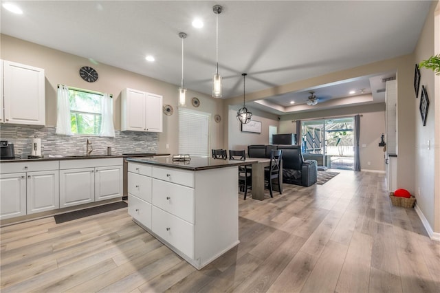 kitchen featuring white cabinetry, sink, light hardwood / wood-style flooring, and ceiling fan