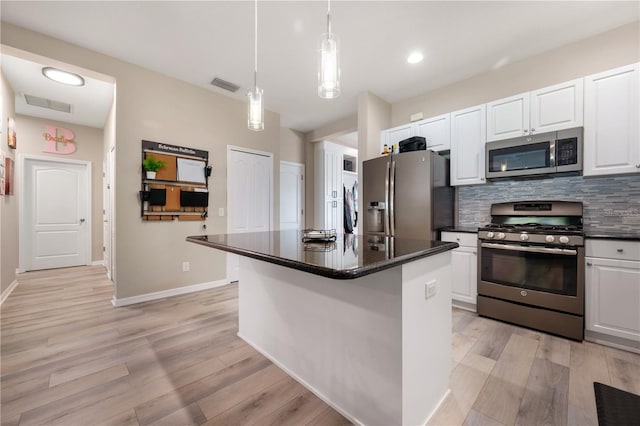 kitchen featuring white cabinets, stainless steel appliances, light wood-type flooring, and a center island