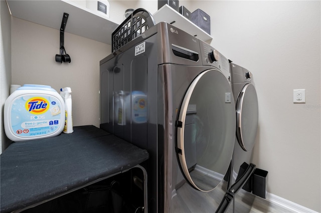 clothes washing area with washing machine and dryer