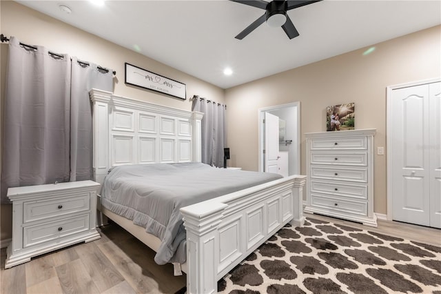 bedroom featuring ceiling fan, hardwood / wood-style flooring, and connected bathroom