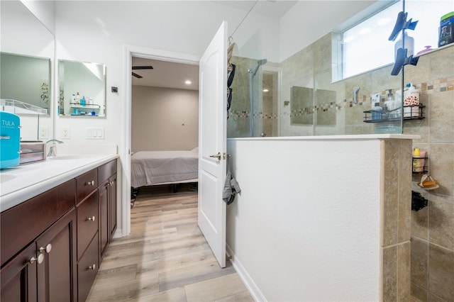 bathroom featuring a tile shower, hardwood / wood-style flooring, and vanity