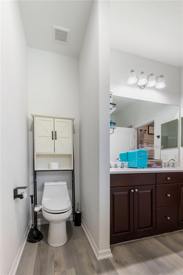 bathroom featuring hardwood / wood-style floors, vanity, and toilet