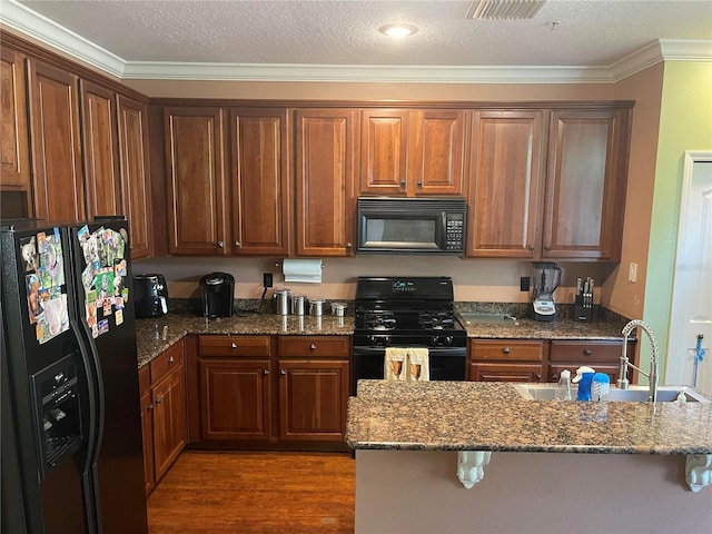 kitchen featuring black appliances, sink, dark stone countertops, and crown molding