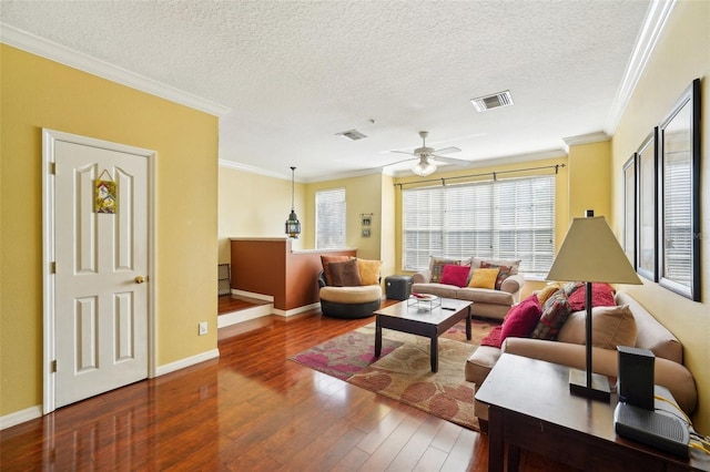 living room with ceiling fan, crown molding, dark wood-type flooring, and a textured ceiling