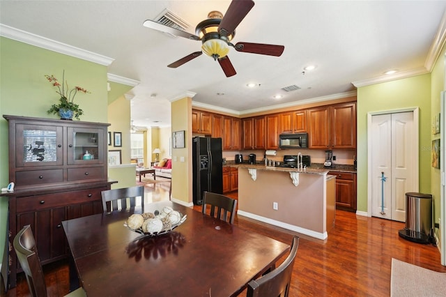 dining space with crown molding, dark hardwood / wood-style floors, sink, and ceiling fan