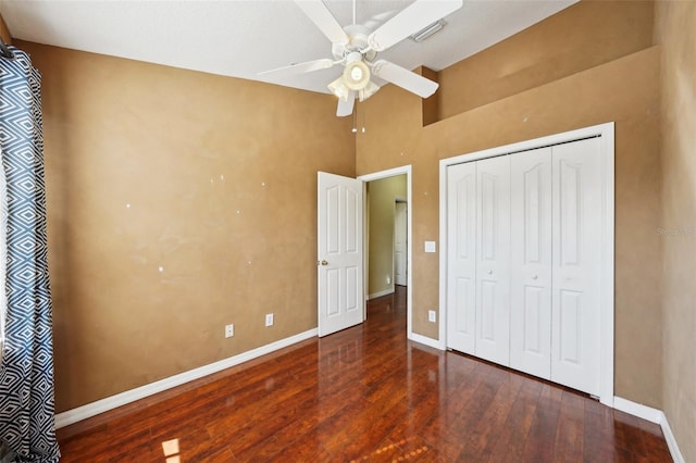 unfurnished bedroom with ceiling fan, dark hardwood / wood-style floors, and a closet