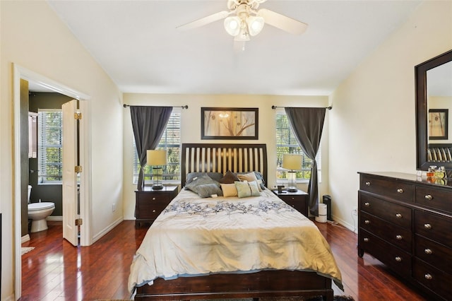 bedroom with dark wood-type flooring, ceiling fan, ensuite bathroom, and multiple windows