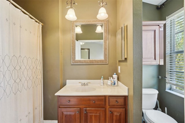 bathroom featuring vanity, walk in shower, and toilet