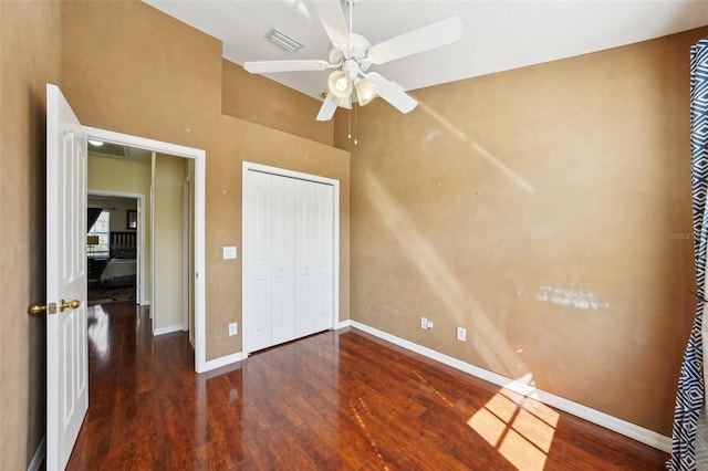 unfurnished bedroom featuring a closet, dark hardwood / wood-style floors, and ceiling fan