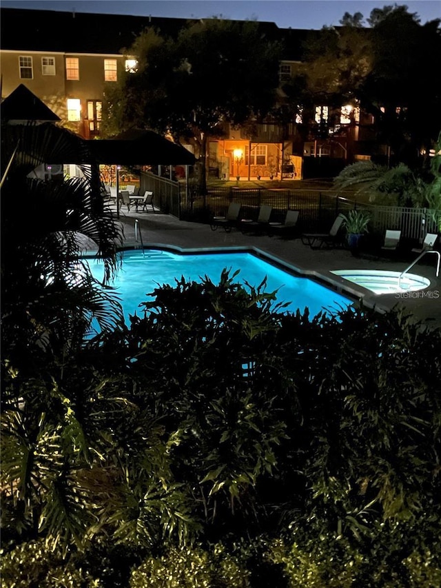 pool at night with a patio area