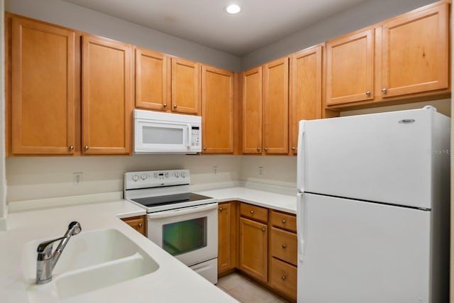 kitchen featuring white appliances, sink, and light tile patterned floors