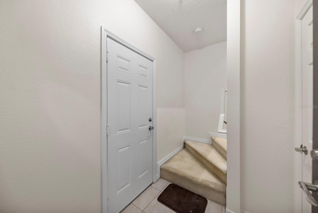 interior space with a textured ceiling and tile patterned floors