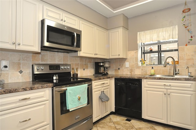 kitchen featuring tasteful backsplash, light tile patterned flooring, sink, white cabinetry, and appliances with stainless steel finishes