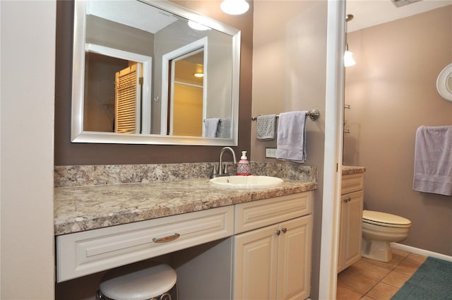 bathroom featuring tile patterned flooring, vanity, and toilet