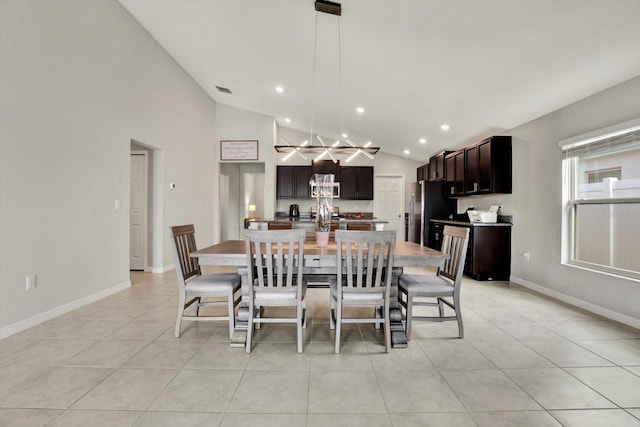 dining area with lofted ceiling and light tile patterned floors