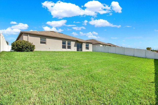 rear view of property featuring a yard