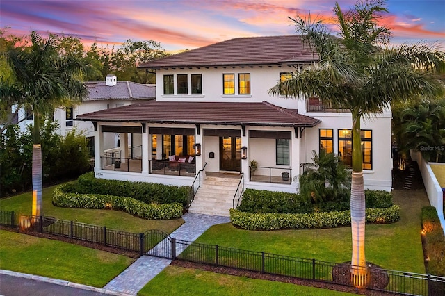 view of front of home with a porch and a lawn