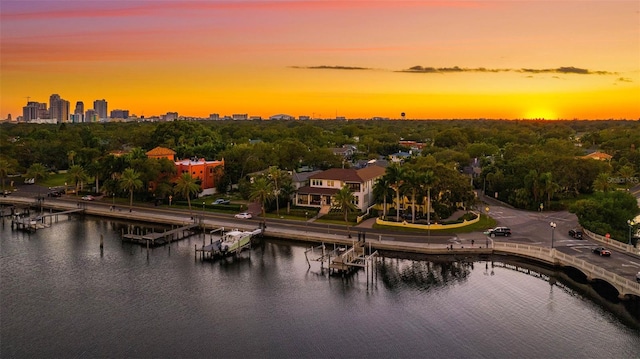 aerial view at dusk featuring a water view