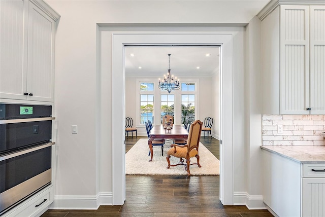 dining room with a chandelier, dark hardwood / wood-style floors, and crown molding