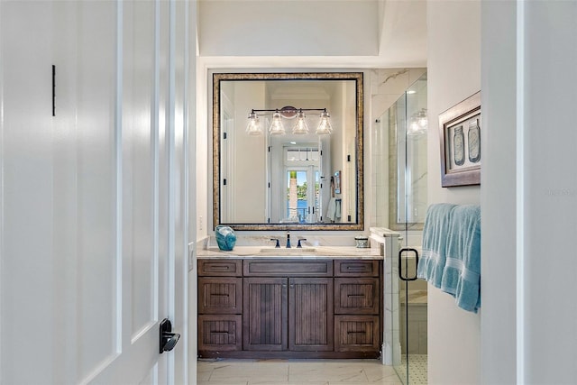 bathroom with a shower with door and vanity